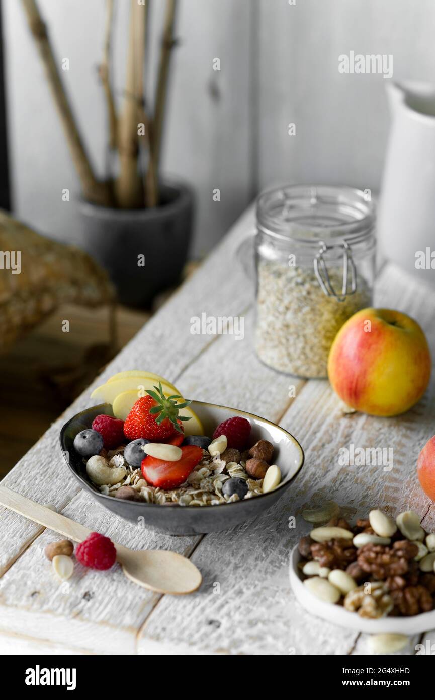 Gesundes Frühstück: Müsli, Obst, Milch auf rustikalem Holztablett Stockfoto