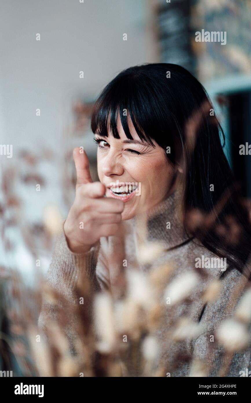 Frau zeigt Handzeichen, während sie im Café ein Gesicht macht Stockfoto