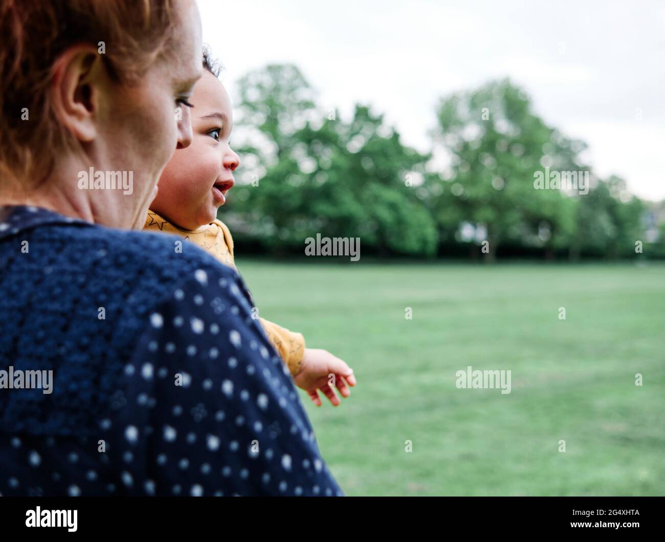 Mutter trägt niedlichen Sohn im Park Stockfoto