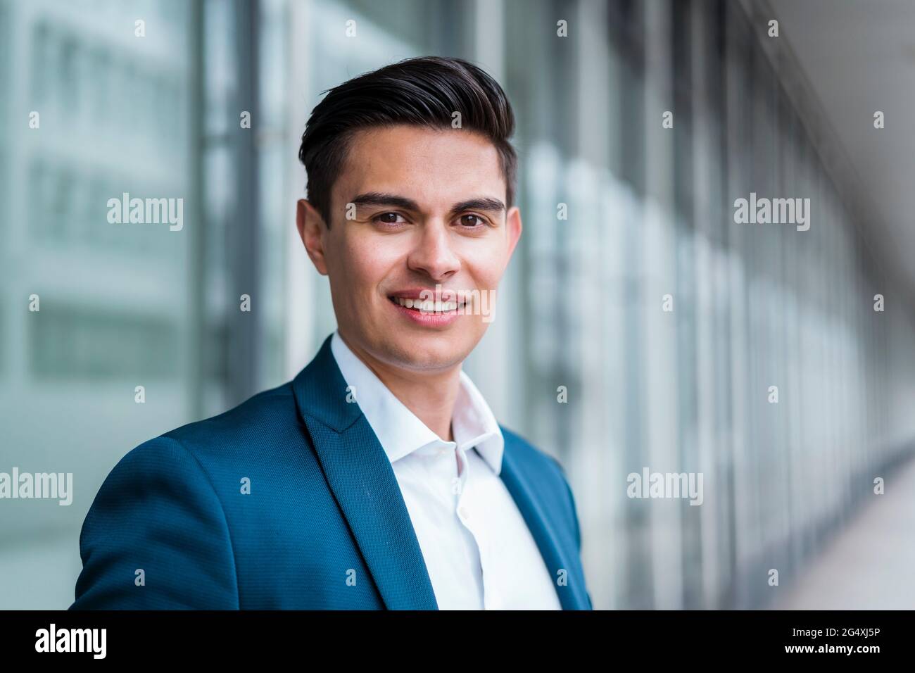 Lächelnder Geschäftsmann, der im Flur steht Stockfoto