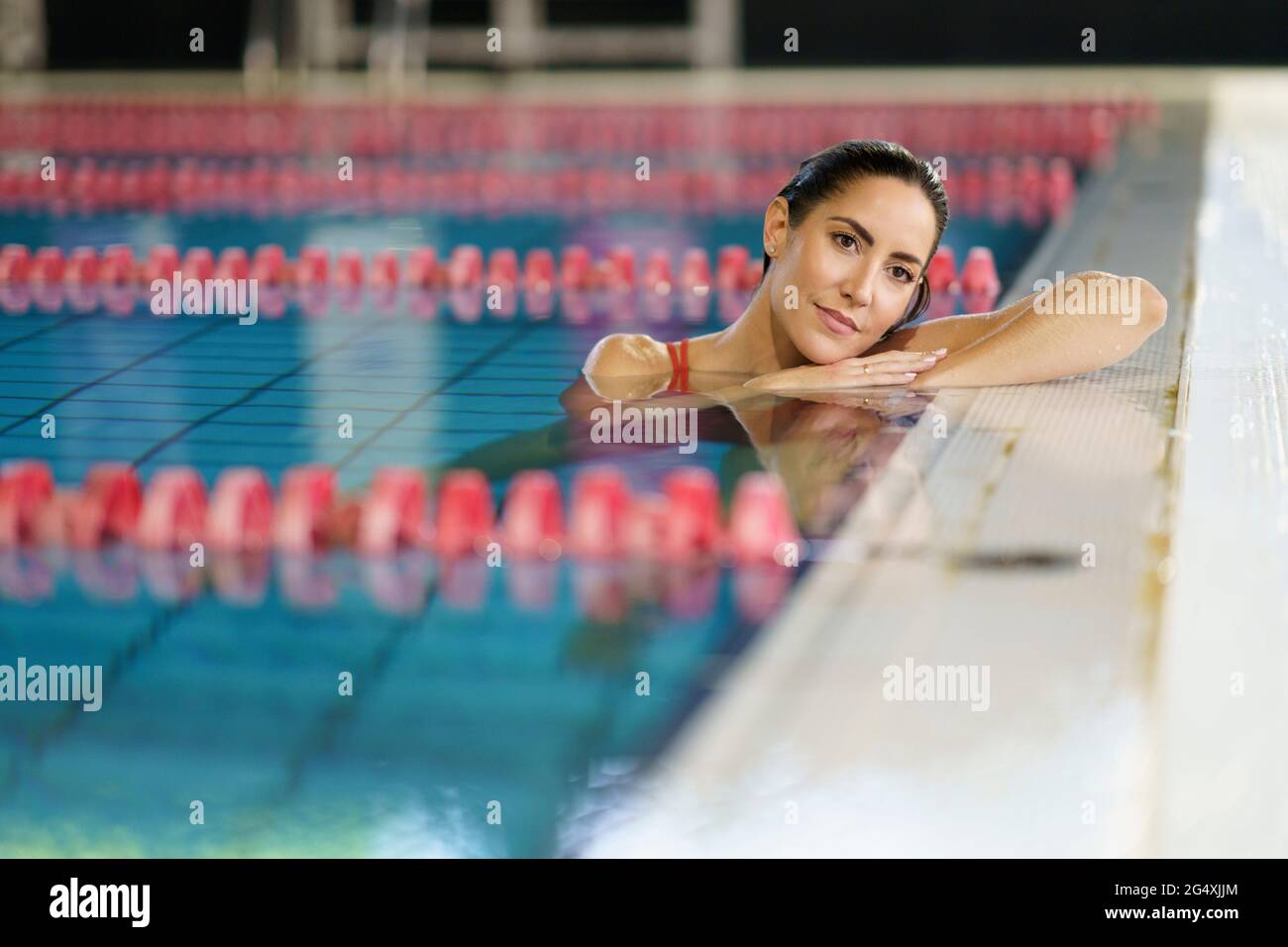 Reife Frau, die im Health Club am Pool gelehnt nachdenkt Stockfoto