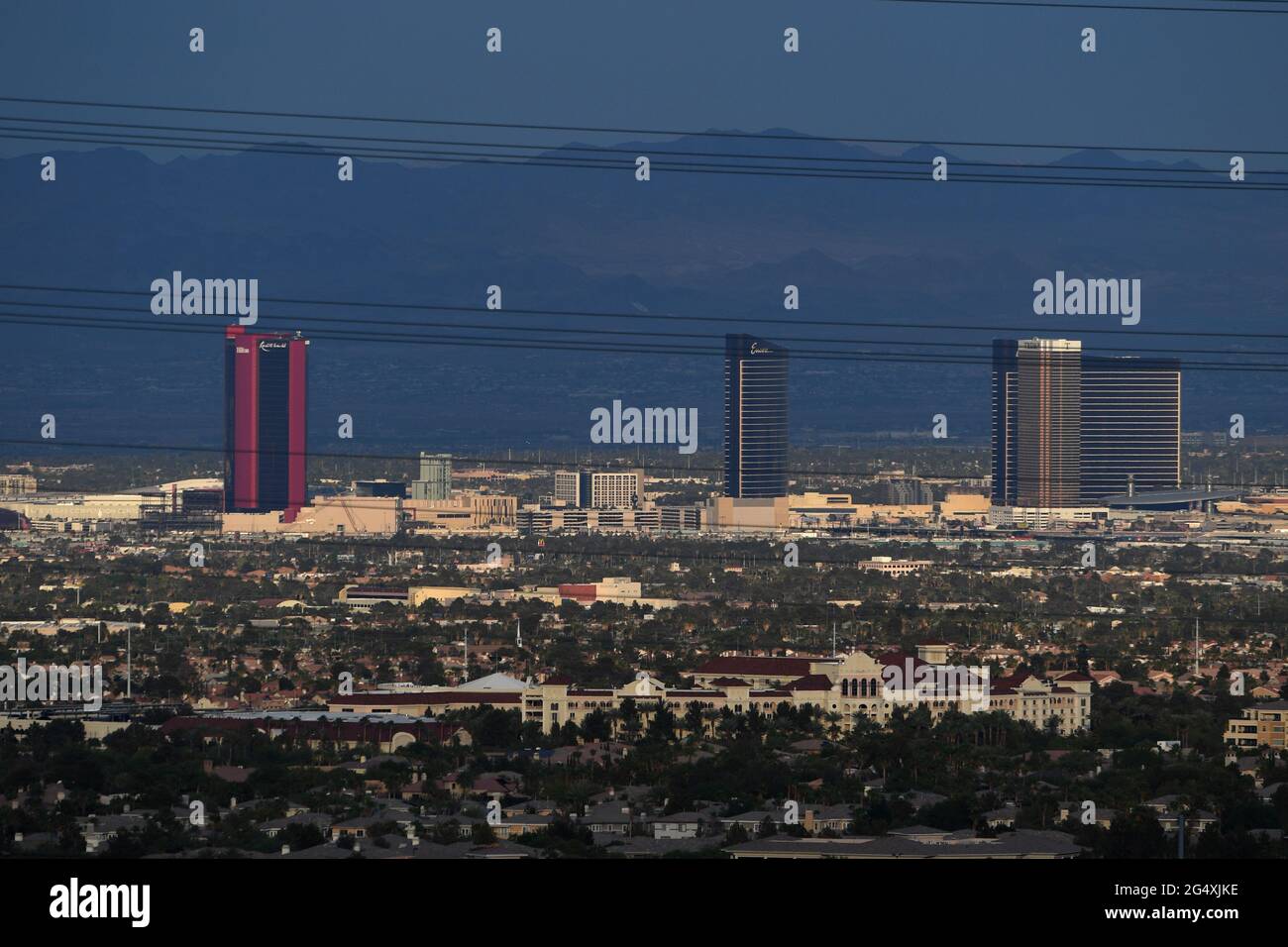 Las Vegas, Nevada, USA. Juni 2021. Ein Foto aus der ganzen Stadt zeigt die Resorts World Las Vegas (roter Turm), die am 23. Juni 2021 in Las Vegas, Nevada, durch Stromleitungen gesehen wurden. Die Eröffnung des Konzessionsgebiets der Genting Group ist für den 24. Juni 2021 auf dem ehemaligen Gelände des Stardust Resort & Casino geplant. Das 4 Milliarden Dollar teure Resort ist das erste neue Resort, das seit der Eröffnung der Cosmopolitan of Las Vegas im Jahr 2010 auf dem Las Vegas Strip errichtet wurde und das teuerste Hotel sein wird, das je in Las Vegas entwickelt wurde. Es wird über drei Türme mit 3,500 Gästezimmern und Suiten sowie ein 117,000 Quadratmeter großes Kasino verfügen Stockfoto