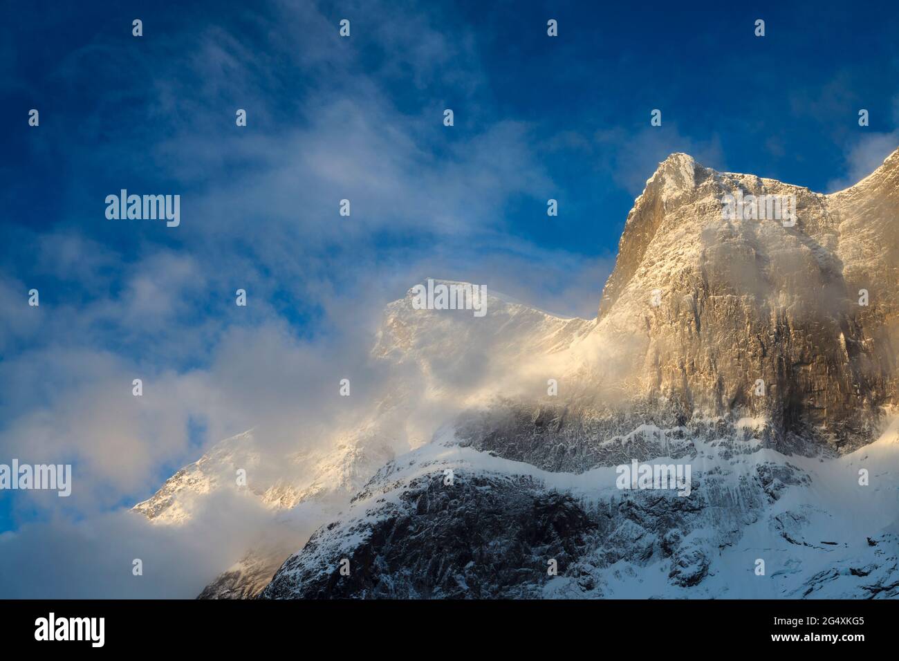 Frühmorgens goldene Stunde Sonnenlicht auf verschneiten und nebligen Bergen im Romsdalen Tal, Rauma kommune, Møre Og Romsdal, Norwegen, Skandinavien. Stockfoto
