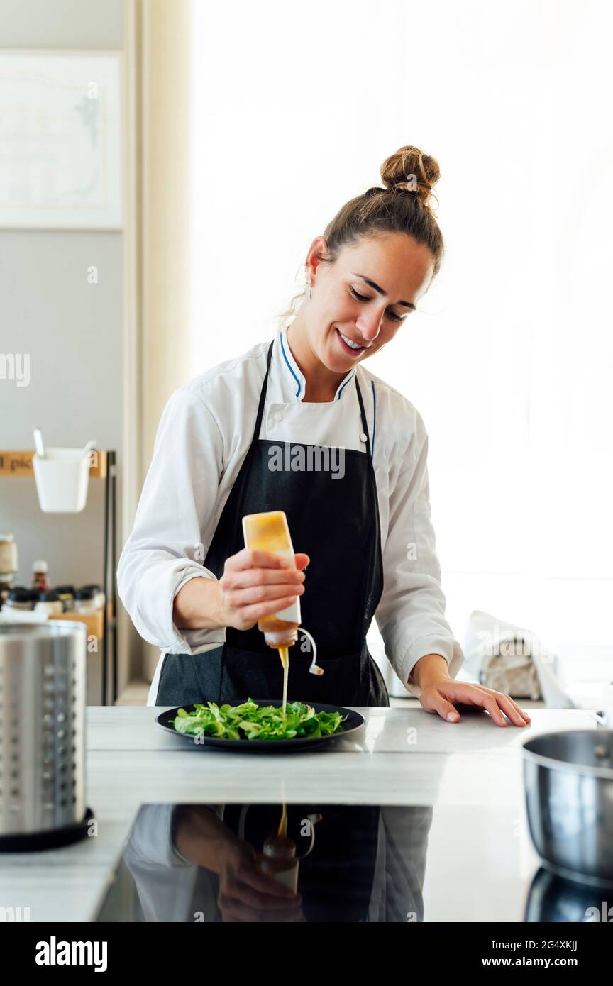 Lächelnde Köchin im Vorfeld, die im Restaurant Essen zubereitet Stockfoto