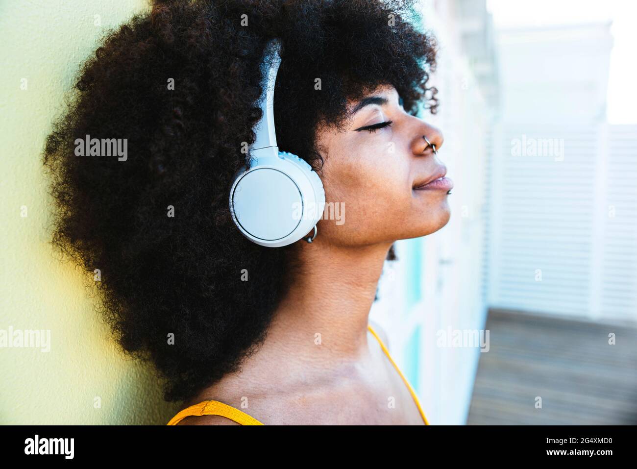 Afro-Frau, die sich auf der Strandhütte lehnte, während sie Musik hörte Stockfoto