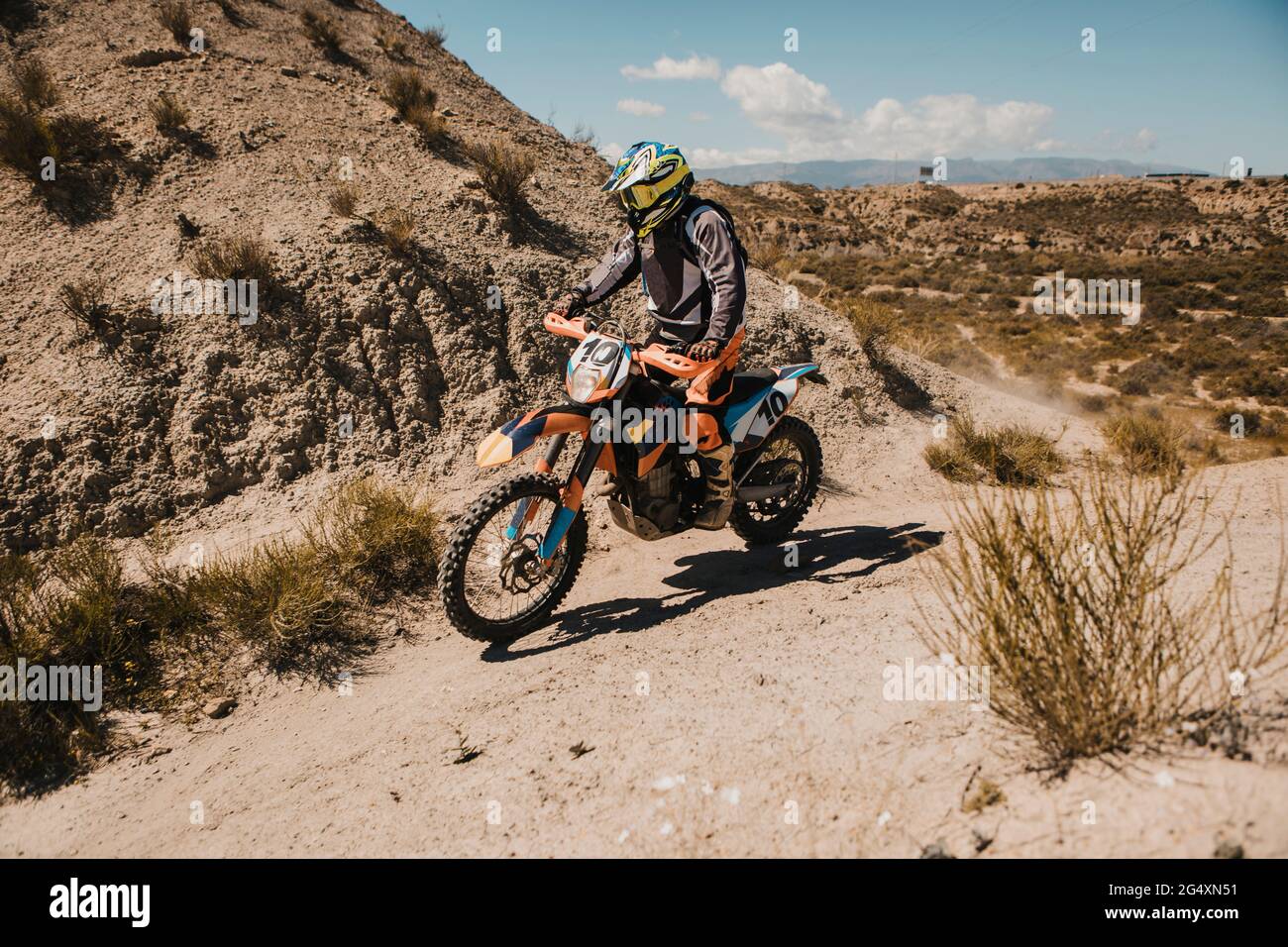 Männlicher Biker in schützender Sportkleidung Motorrad auf unbefestigten Straßen fahren Stockfoto