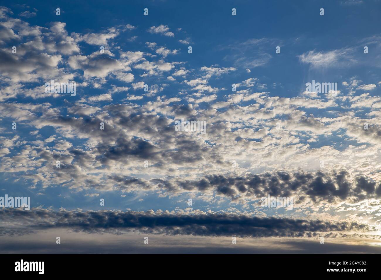Schöner blauer Himmel mit weißen Zirruswolken bei Sonnenuntergang. Himmelspanorama für Bildschirmschoner, Postkarten, Kalender, Präsentationen. Tiefer Punkt bei Weitwinkel. Warme Frühlings- oder Sommerabende. Stockfoto