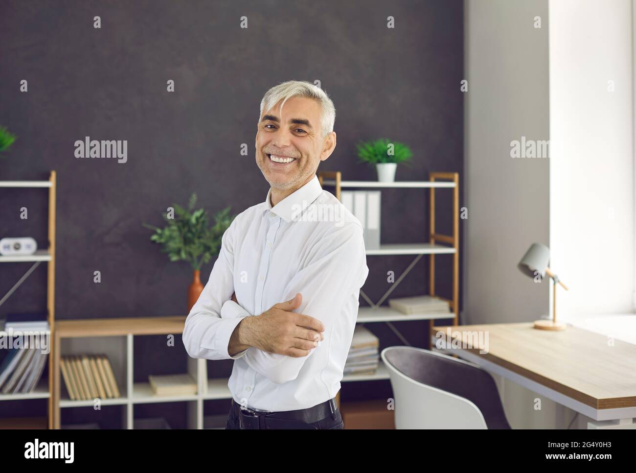 Porträt eines erfolgreichen glücklichen und lächelnden älteren kaukasischen Geschäftsmannes oder Büroangestellers. Stockfoto