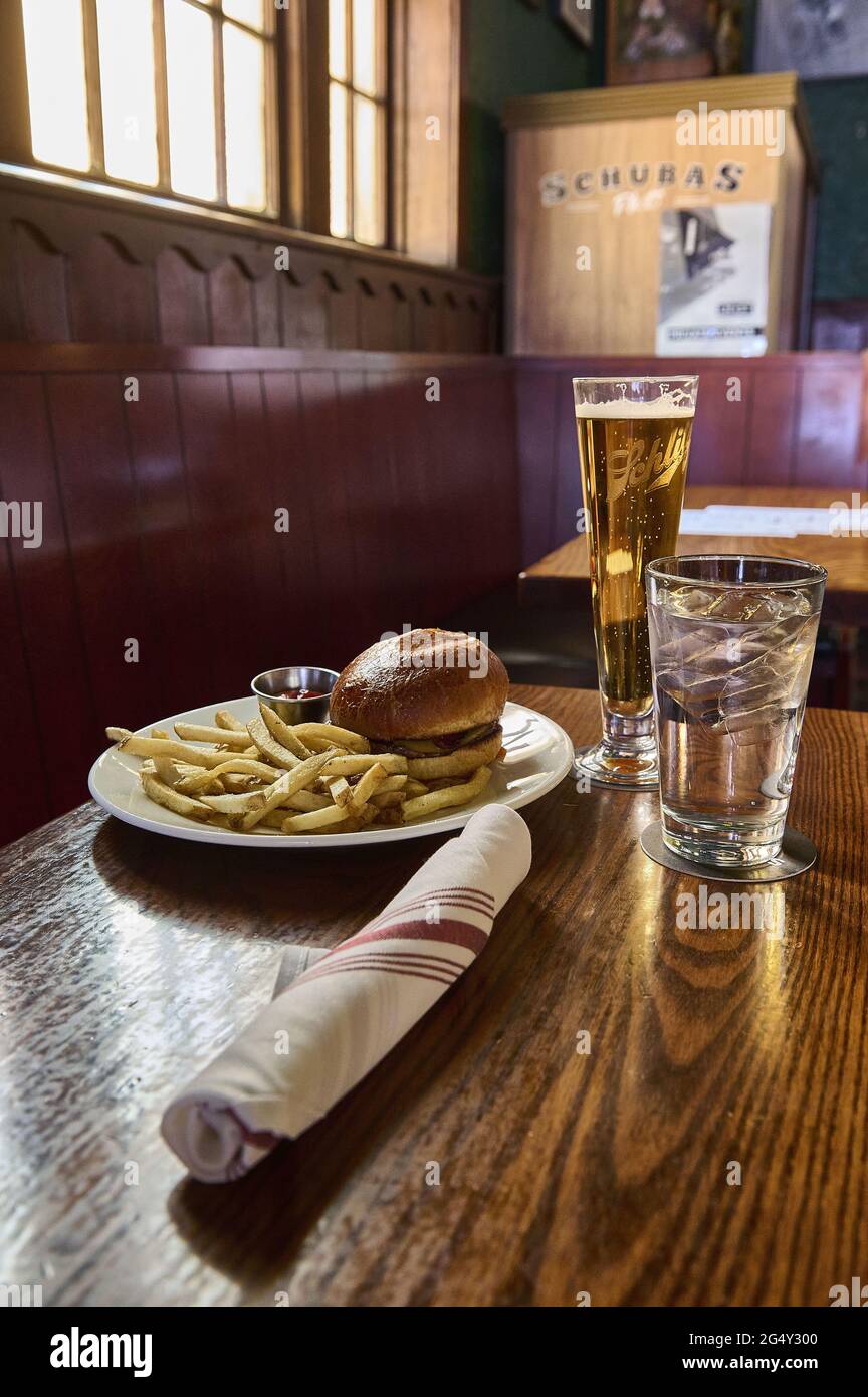 USA, Chicago: hamburger und Pommes, ein Glas Wasser, Handtuch und Bier in der Schubas Tavern. Stockfoto