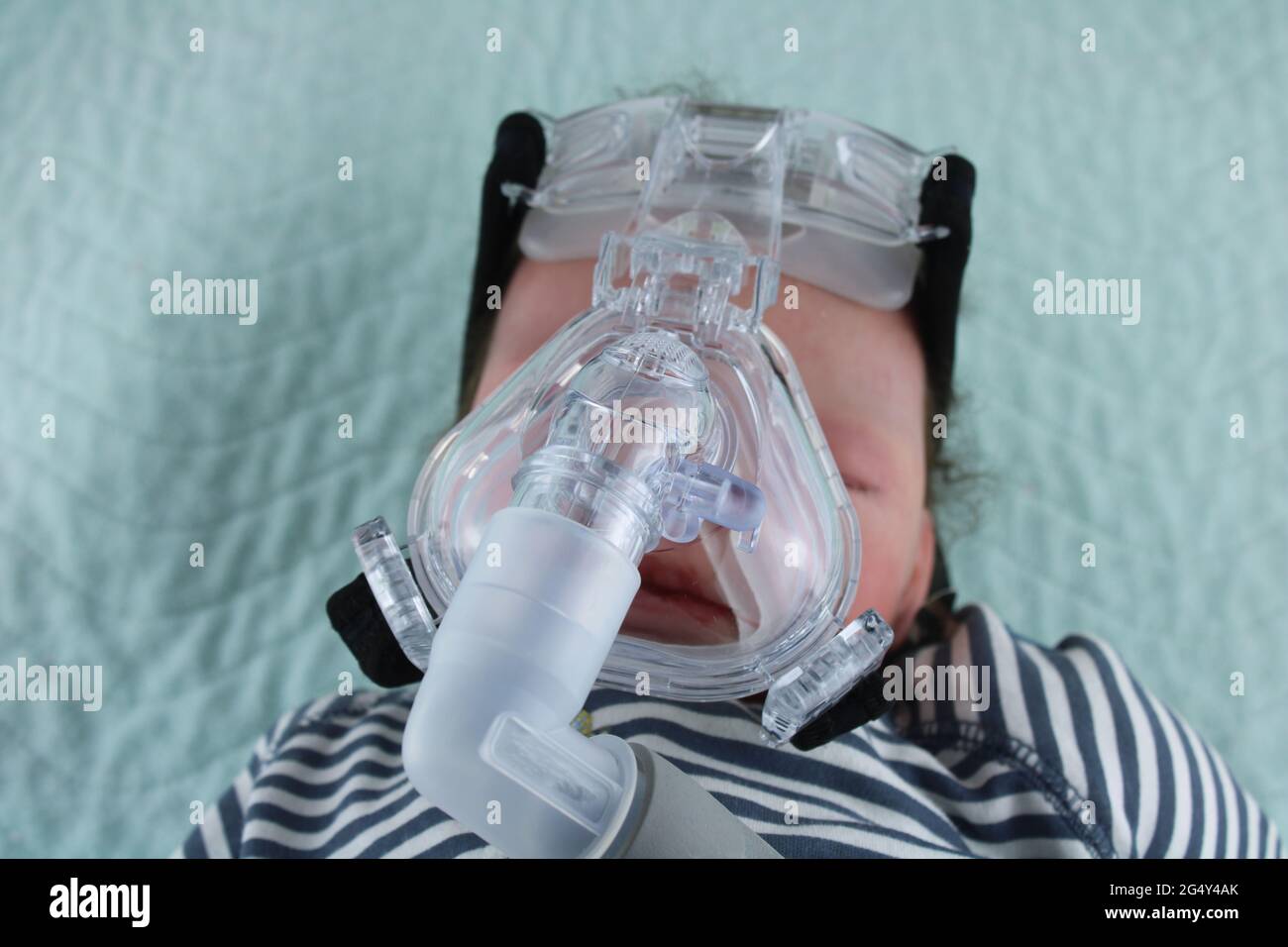 Baby trägt Sauerstoffmaske, Asthma bei Kindern und das Konzept des Respiratory Syncytial Virus, dargestellt durch eine wiedergeborene Puppe, die eine cpap-Maske trägt Stockfoto