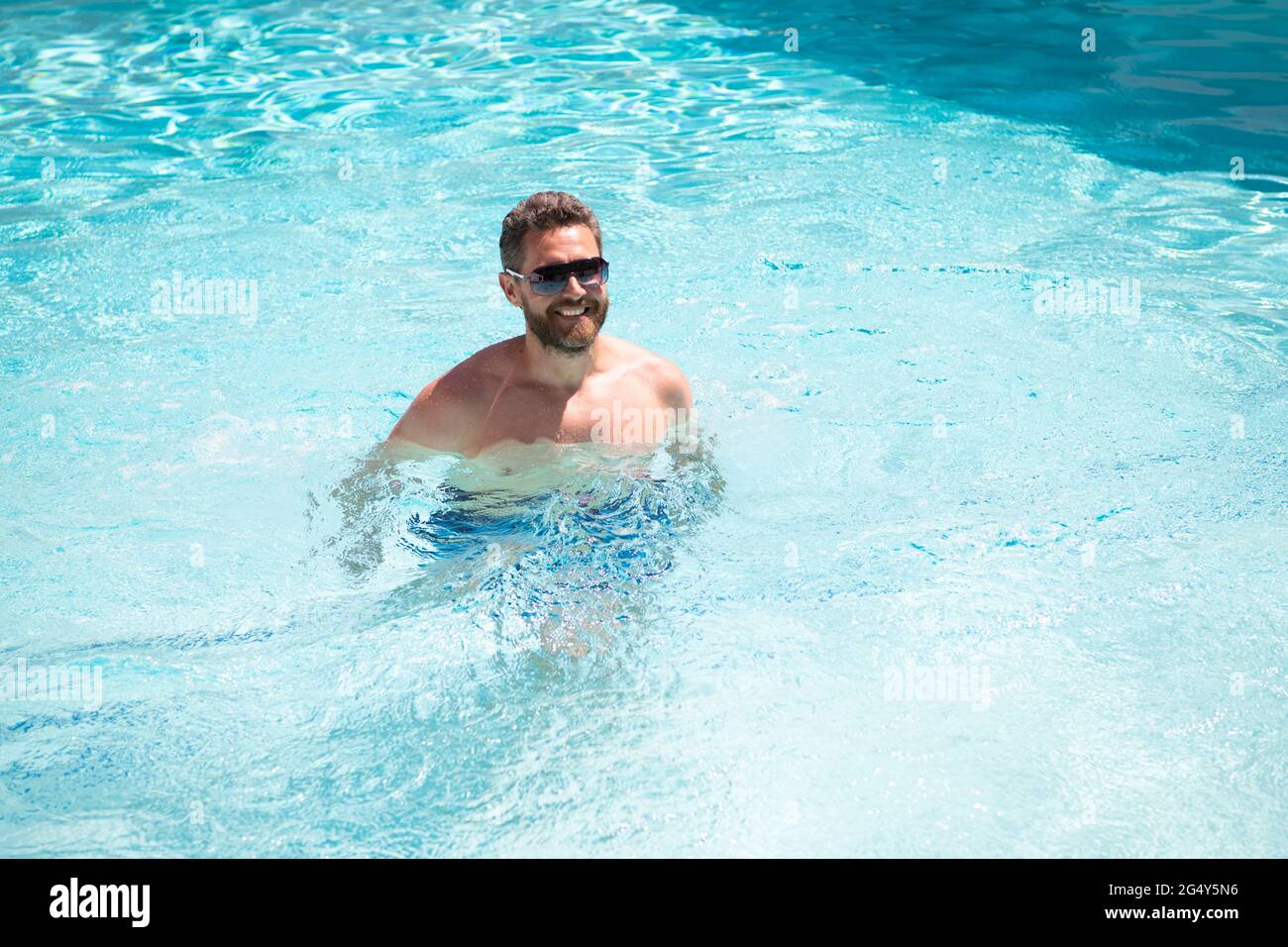 Glücklicher bärtiger Mann in Sonnenbrillen Genießen Sie Entspannung im Spa Resort Schwimmbad im Sommerurlaub, Sommer. Stockfoto