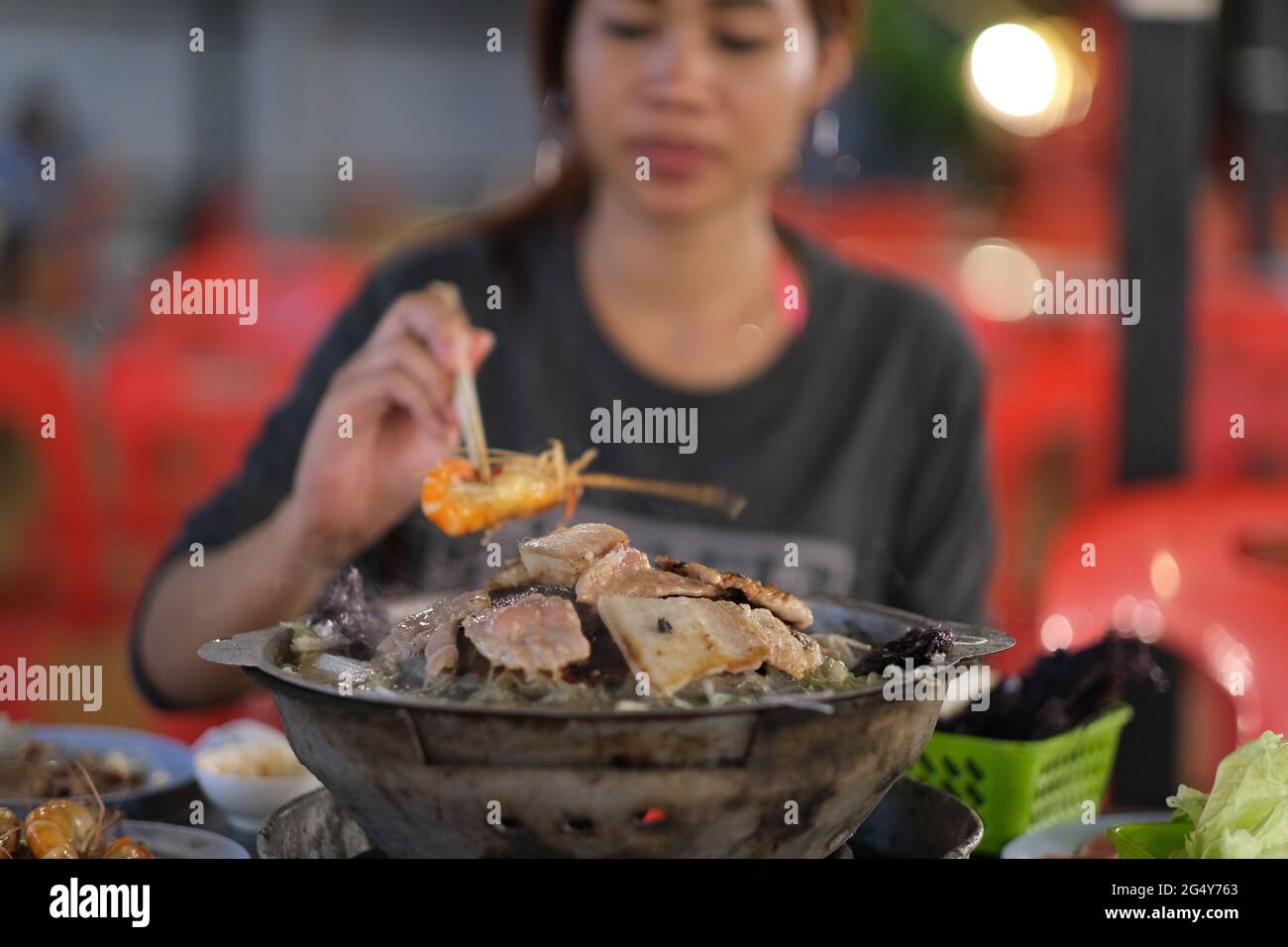 Hübsche thailändische Frauen essen am traditionellen thailändischen Buffet - Mookata Stockfoto