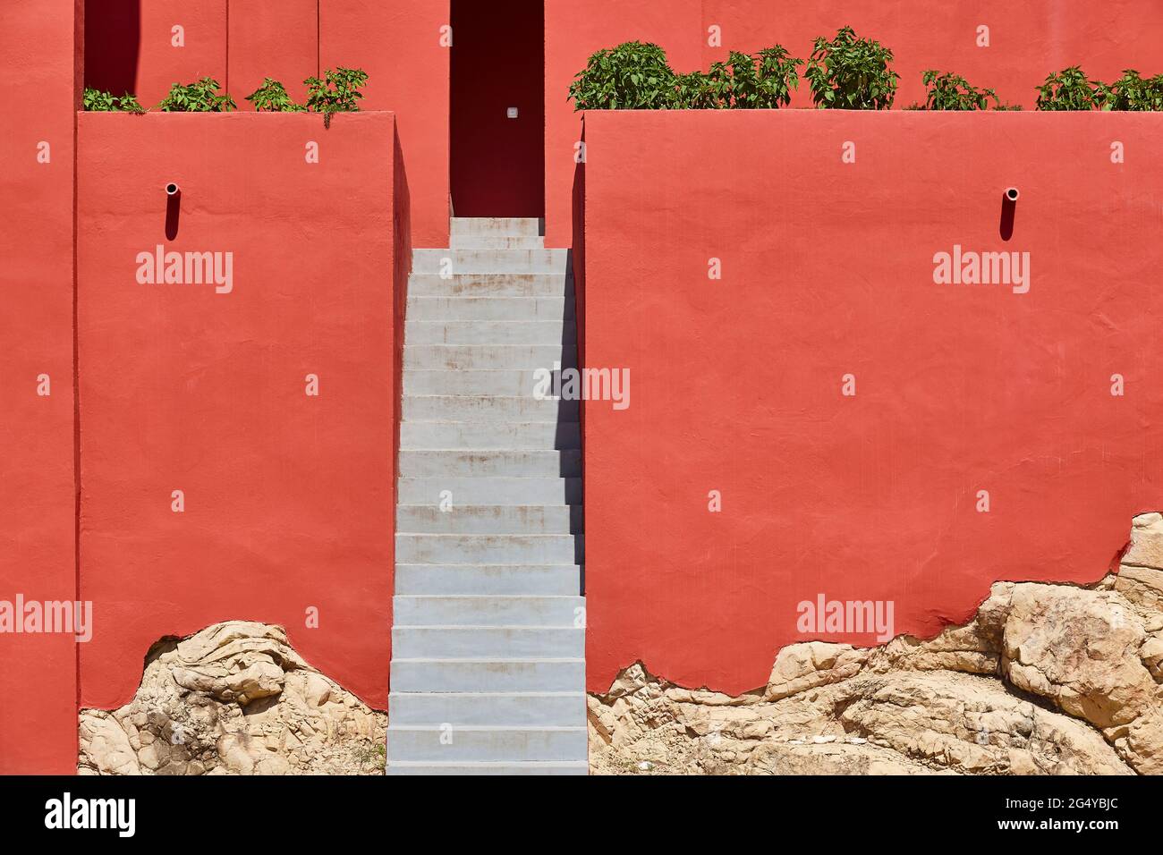 Geometrisches rotes Gebäudedesign. Die rote Mauer, La manzanera. Calpe, Spanien Stockfoto