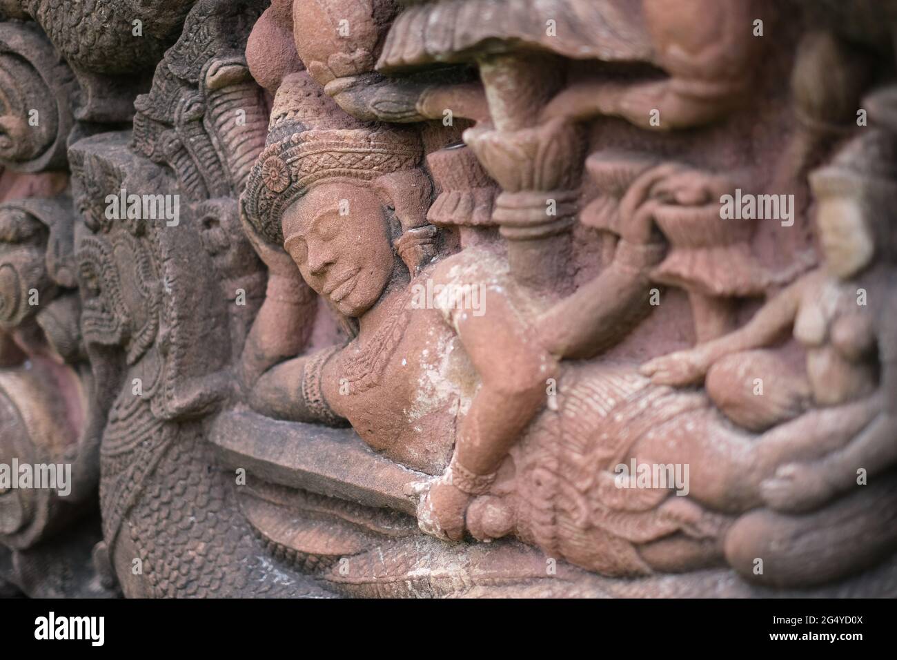 Eine geschnitzte Steinfigur eines schlafenden Königs, im alten khmer-Stil, mit einem Schwert und einer Frau Stockfoto