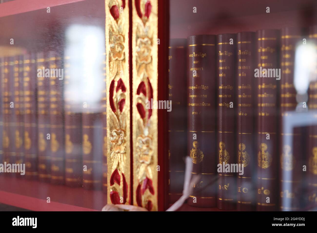 Tripitaka, eine Reihe von Büchern des heiligen buddhismus, ist in einem heimischen Holzschrank im thailändischen Stil zu sehen Stockfoto