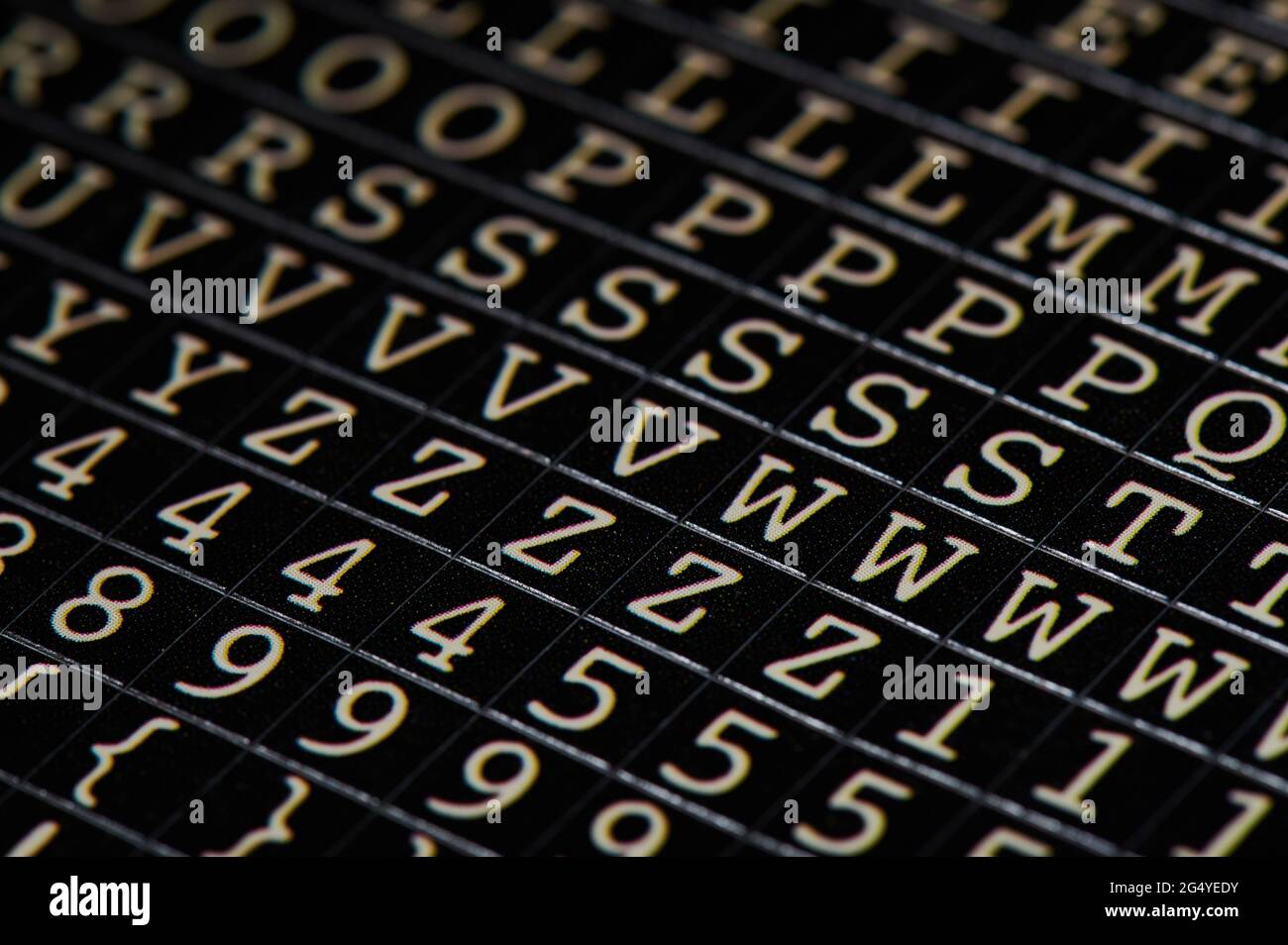 Aufkleber mit Buchstaben und Zahlen auf schwarzem Papier verschwommener Hintergrund Stockfoto