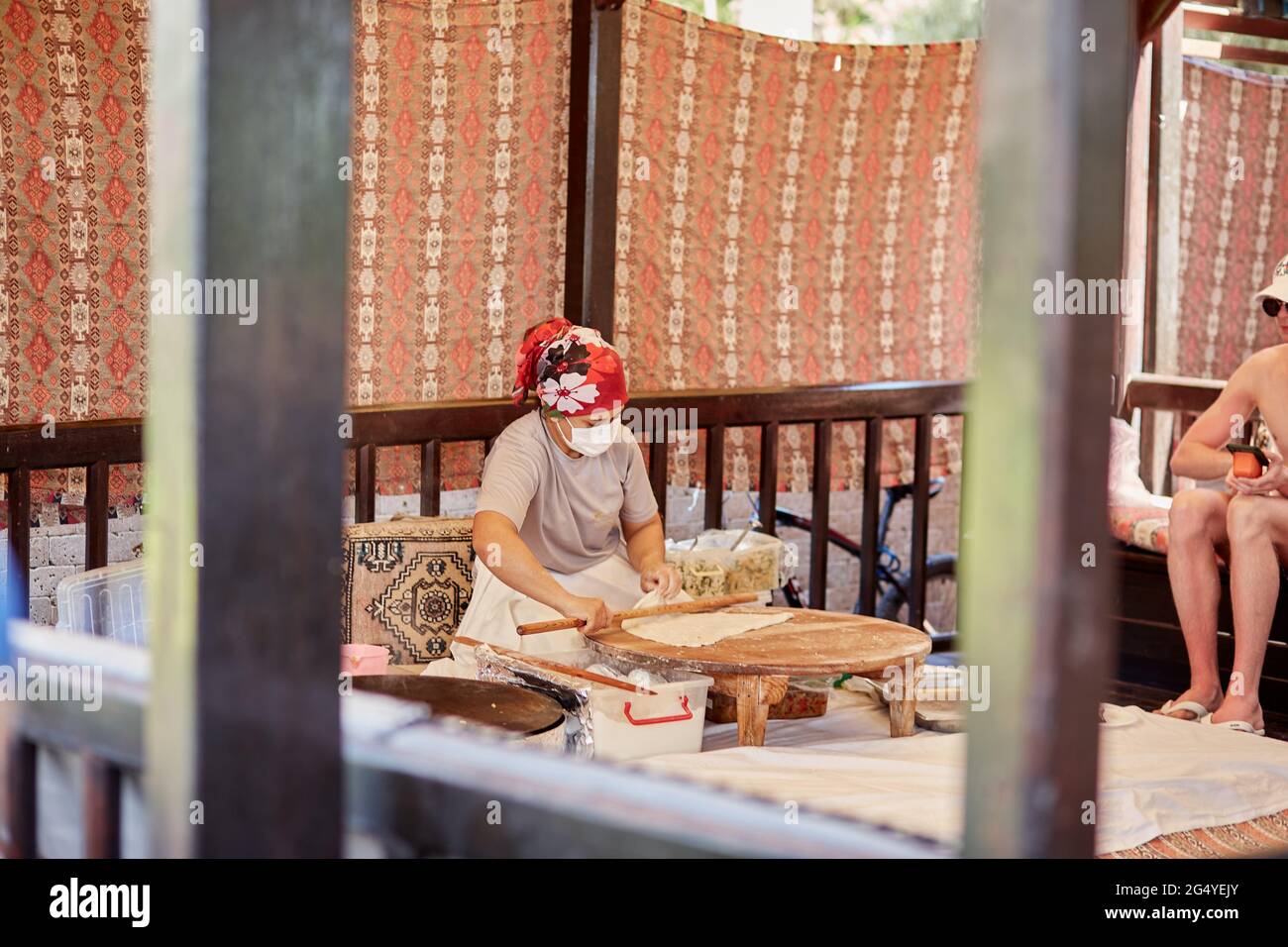 Kemer, Türkei - 25. Mai 2021: Frau bereitet im Freien nationales türkisches Fladenbrot zu. Teigvorbereitung. Türkische kulinarische Traditionen in der Küche. High qu Stockfoto