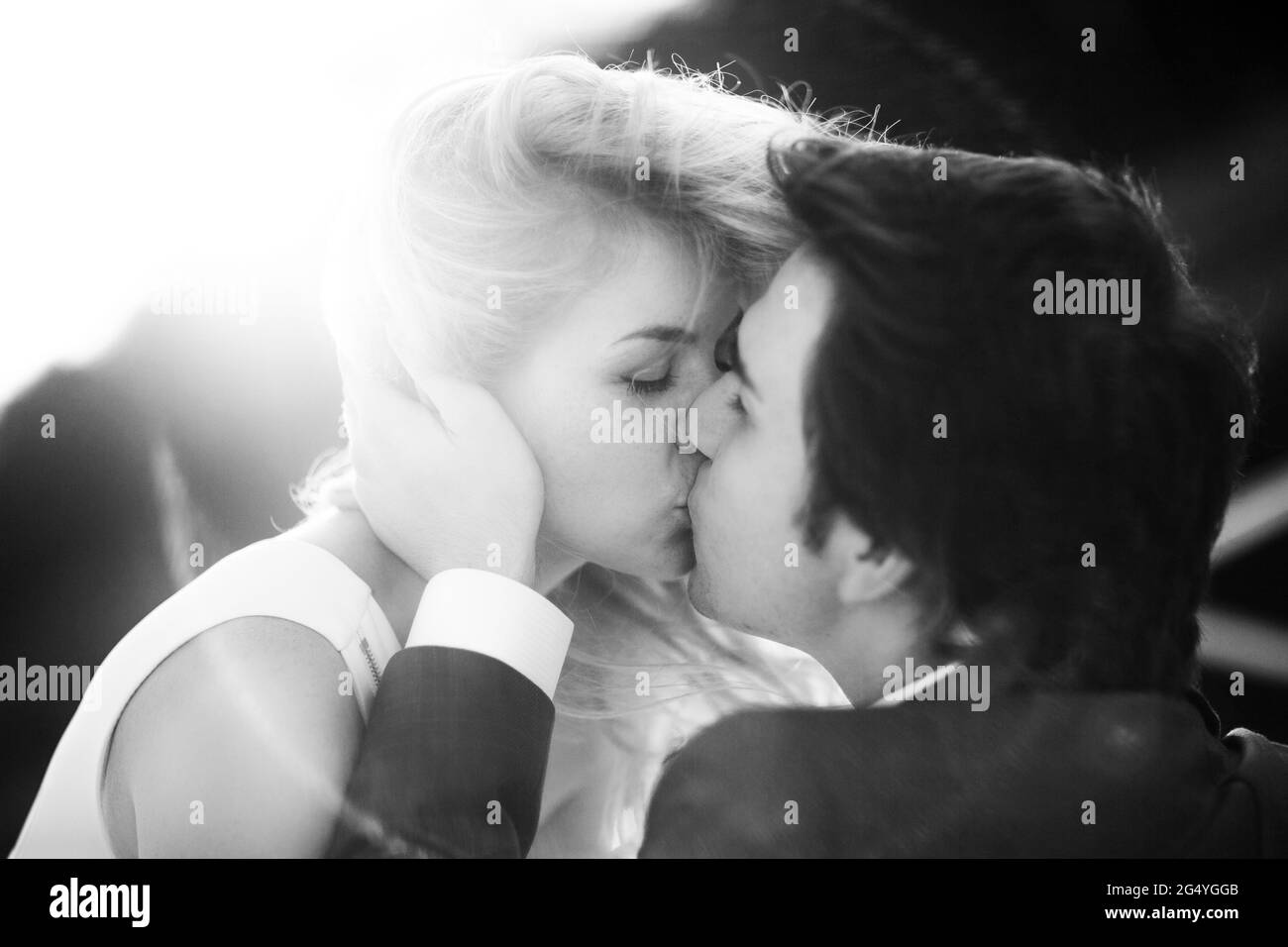 Brautpaar Braut und Bräutigam zusammen küssen schwarz-weiß Bild. Stockfoto