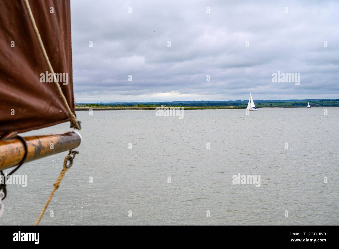 Zwei Segelboote in der Ferne an der Themsemündung vom historischen Segelschiff „Edith May“ aus gesehen. Kent, England. Stockfoto