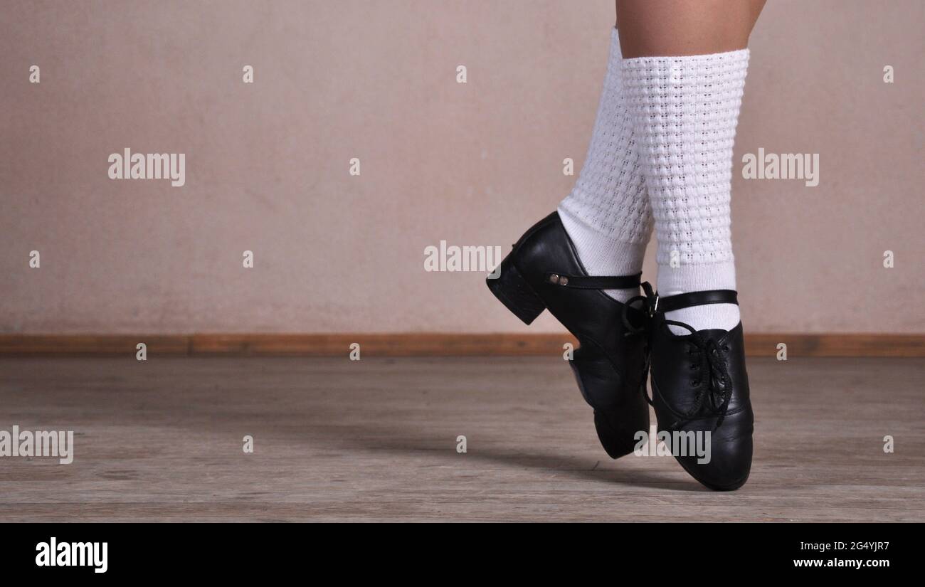 Nahaufnahme von weiblichen Beinen in schwarzen Lederschuhen, die nationale irische Tänze tanzen. Stockfoto