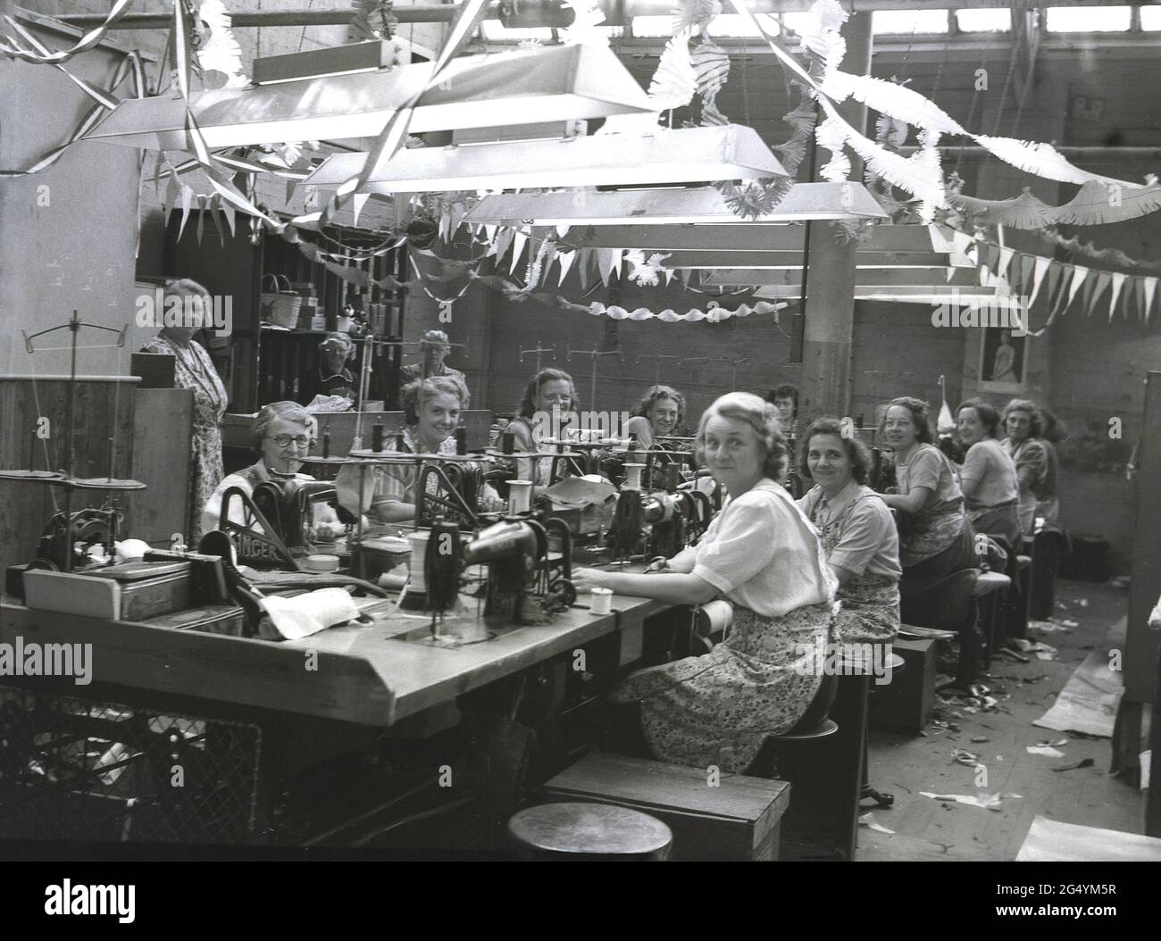 1953, historische Arbeiterinnen, die mit ihren Nähmaschinen in der Hepworths-Bekleidungsfabrik, Claypit Lane, Leeds, England, Großbritannien, sitzen. Stockfoto