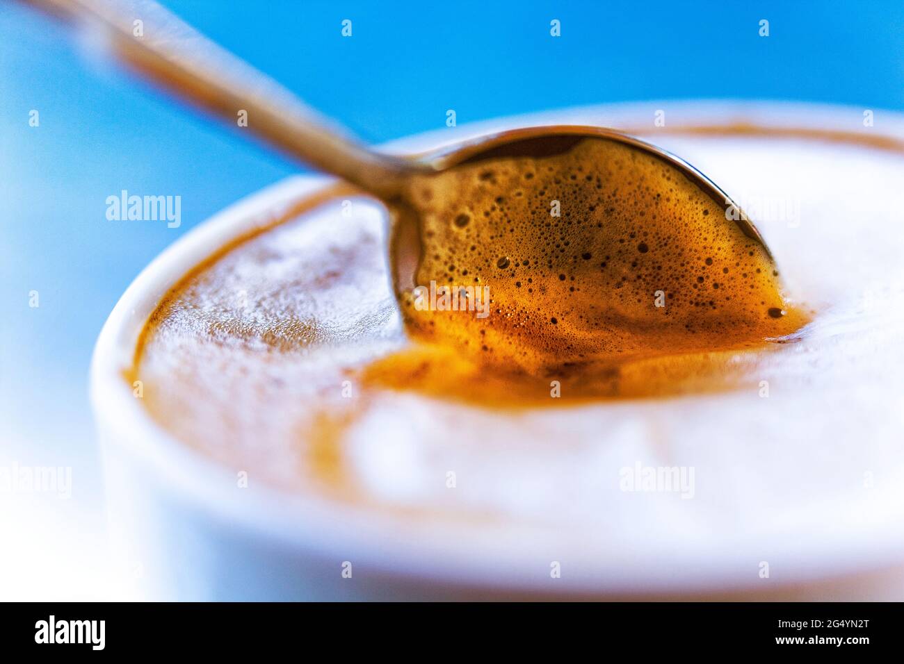 Cafe Latte (caffè e Latte) Espresso mit schaumiger Milch und Löffel in  einer Tasse, fotografiert mit einer Lensbaby Composer Linse für einen  weichen Fokus-Effekt Stockfotografie - Alamy