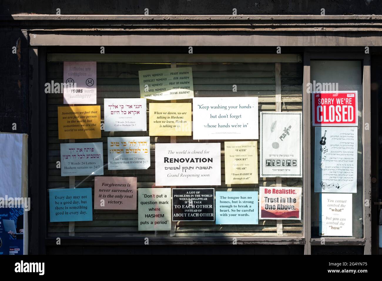 Inspirierende Schilder in den Fenstern eines geschlossenen Ladens auf der Lee Avenue in Williamsburg, Brooklyn, einem orthodoxen jüdischen Viertel. Stockfoto