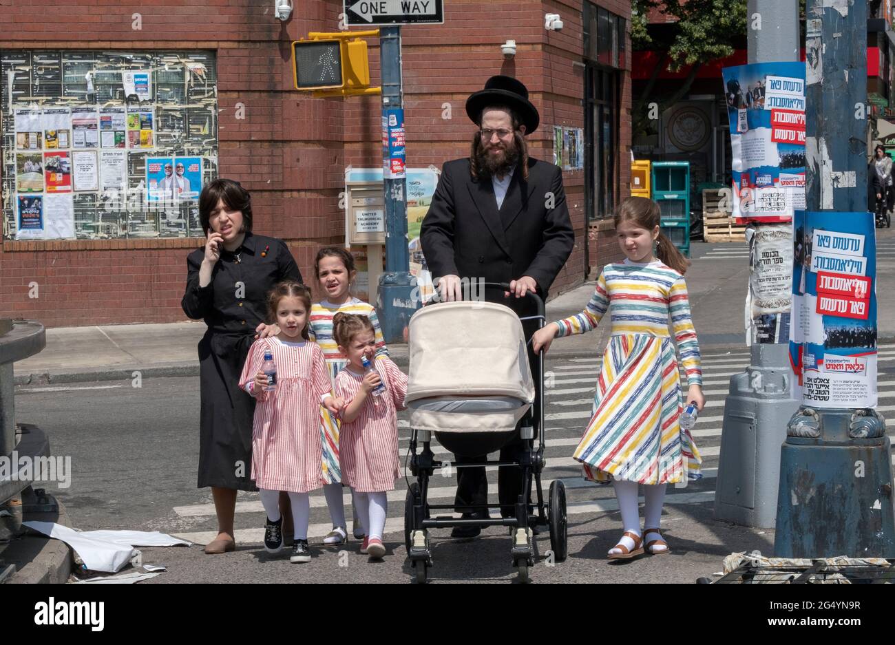 Eine chassidische Familie, die auf der Lee Avenue in Williamsnurg spazieren geht. Die Töchter haben passende Kleidungsstücke. Stockfoto