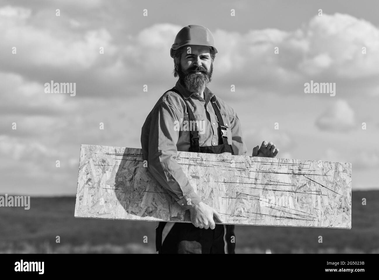 Holzwerkstoff. Provisorische Ausrüstung oder Strukturen montieren. Renovierungsservice. Mann trägt Faserplatten. Faserplatten in Wohn- und Stockfoto