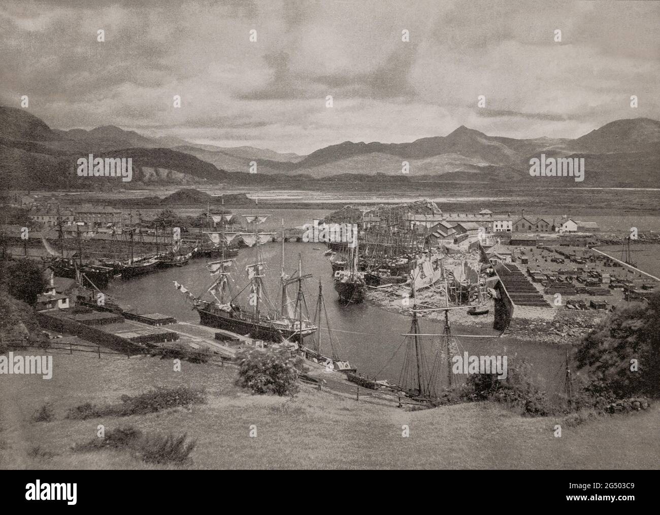 Ein Blick aus dem späten 19. Jahrhundert auf den kleinen Hafen Porthmadog aka Portmadoc, eine walisische Küstenstadt im Eifionydd-Gebiet von Gwynedd und der historischen Grafschaft Caernarfonshire. Es entwickelte sich im 19. Jahrhundert als Hafen für Schiefer als Steinbruchfirmen, wobei Werfer Schiefer aus Ffestiniog exportierten. Stockfoto Ein Blick aus dem späten 19. Jahrhundert auf den kleinen Hafen Porthmadog aka Portmadoc, eine walisische Küstenstadt im Eifionydd-Gebiet von Gwynedd und der historischen Grafschaft Caernarfonshire. Es entwickelte sich im 19. Jahrhundert als Hafen für Schiefer als Steinbruchfirmen, wobei Werfer Schiefer aus Ffestiniog exportierten. Stockfoto