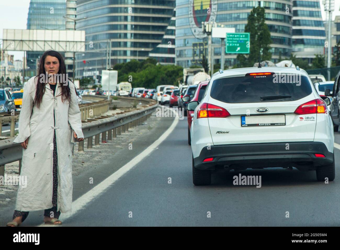 Eine Bettlerin bettelt zur Hauptverkehrszeit auf der Autobahn in Istanbul. Stockfoto