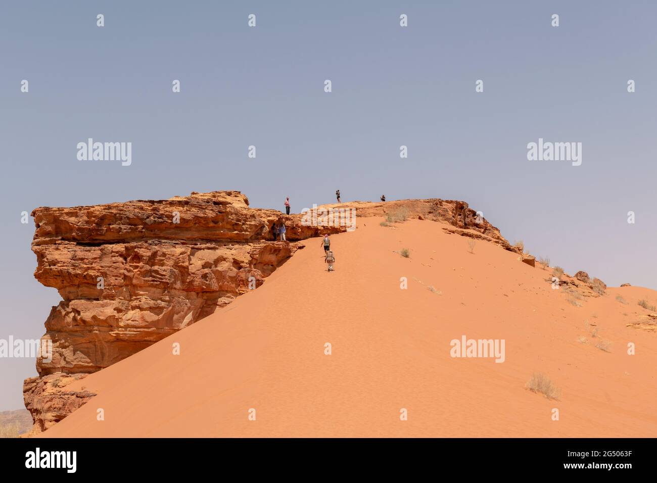 Touristen, die das Wadi Rum Schutzgebiet erkunden. Wadi Rum oder Valley of the Moon ist berühmt für seine atemberaubende Wüstenlandschaft, Wüstentäler und Dünen. Stockfoto