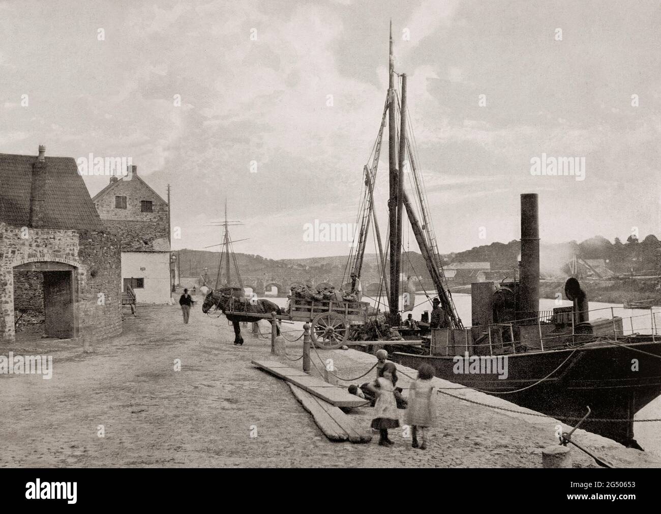 Ein Blick aus dem späten 19. Jahrhundert auf einen kleinen Küstendampfer, der an den Kai in Carmarthen gebunden ist und am Fluss Tywi, Wales, liegt. Ein Blick aus dem späten 19. Jahrhundert auf einen kleinen Küstendampfer, der an den Kai in Carmarthen gebunden ist und am Fluss Tywi, Wales, liegt. Die Kreisstadt Carmarthenshire behauptet, die älteste Stadt in Wales zu sein – Old Carmarthen und New Carmarthen wurden 1546 zu einem Stadtteil. Stockfoto