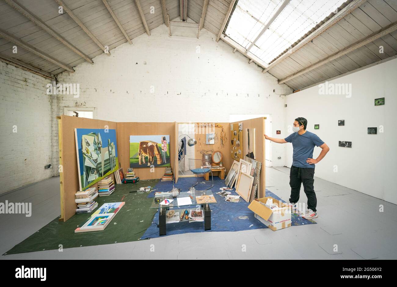 Student Masaki Ishikawa neben seiner ÒHome StudioÓ Installation, die in der Glue Factory in Glasgow, die Teil der Ausstellung der Glasgow School of Art ist ÒHot WheelsÓ mit Werken dieses Absolventen des yearÕs MFA (Master of Fine Arts), zu sehen ist. Bilddatum: Donnerstag, 24. Juni 2021. Stockfoto