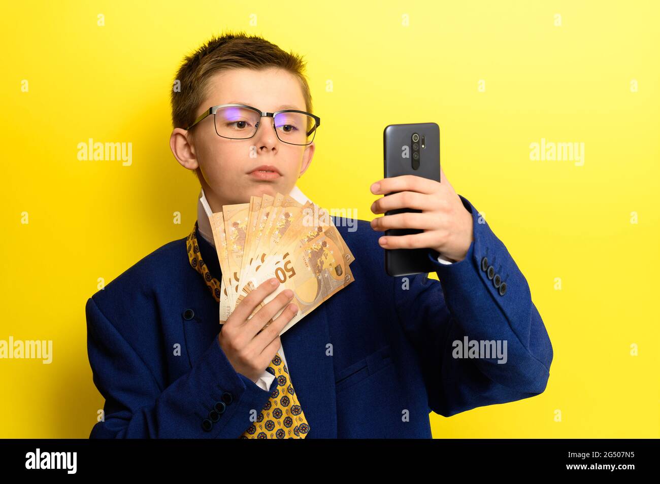 Junge in einem großen Anzug, Selfie auf gelbem Hintergrund mit Geld  Stockfotografie - Alamy