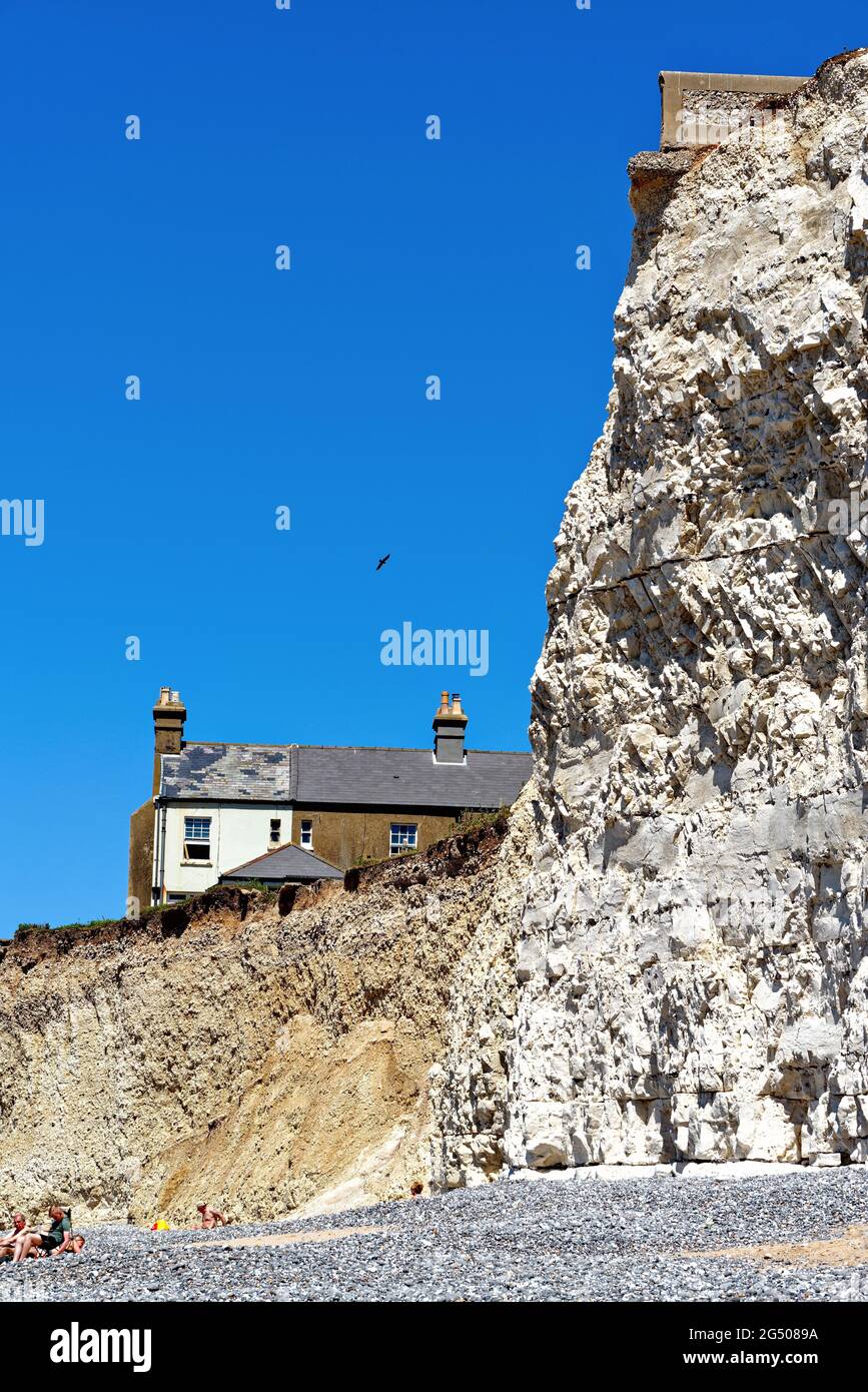 Alte Cottages, die aufgrund der starken Küstenerosion an der Klippe von Birling Gap in der Nähe von Eastbourne East Sussex England, Großbritannien, liegen Stockfoto