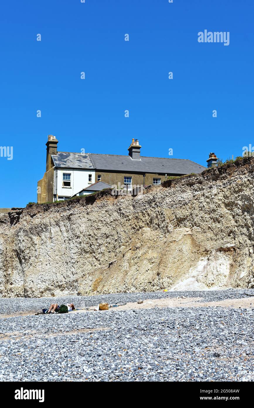 Alte Cottages, die aufgrund der starken Küstenerosion an der Klippe von Birling Gap in der Nähe von Eastbourne East Sussex England, Großbritannien, liegen Stockfoto