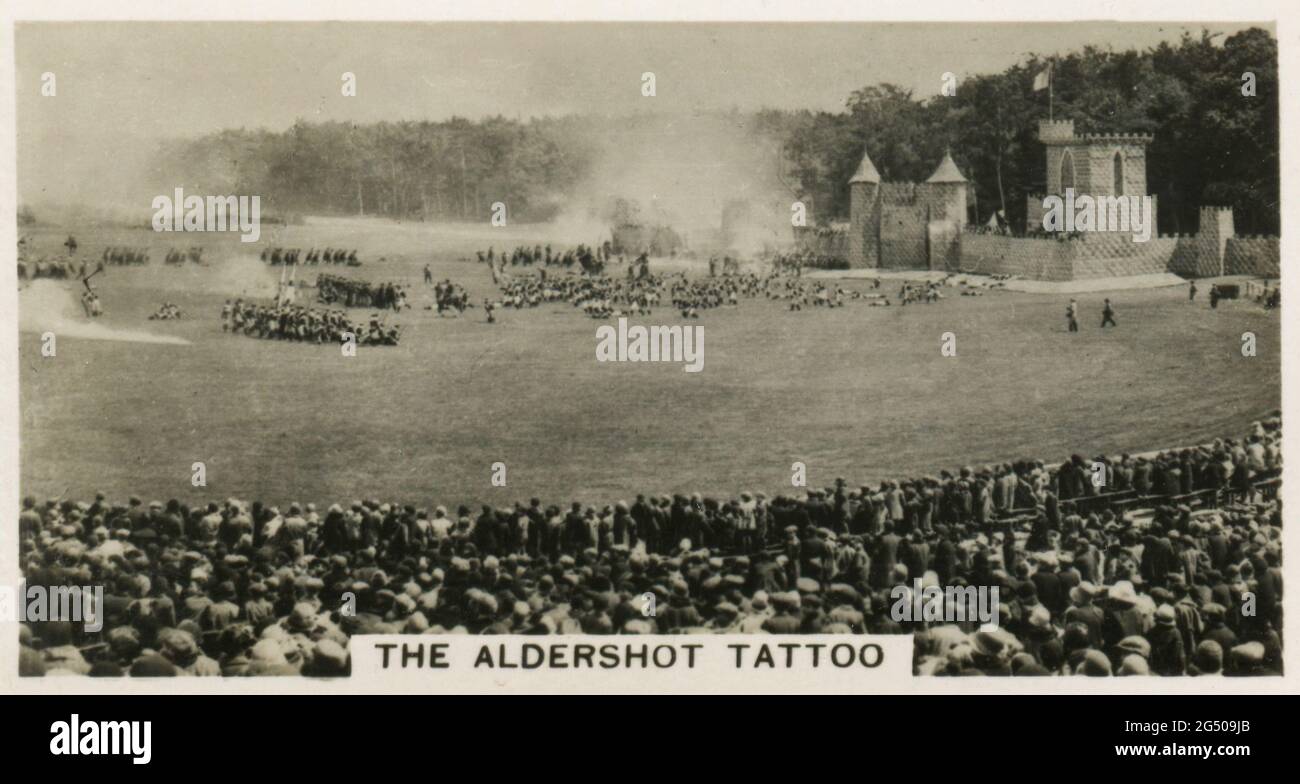 ‘Heimatveranstaltungen’ W.D. UND H.O. Wills Zigarettenkarte mit dem Titel „The Aldershot Tattoo“. „von einer einfachen lokalen militärischen Unterhaltung, organisiert von den Truppen des Aldershot Command, hat das Aldershot Tattoo bis jetzt den Status eines brillanten Musikfestivals von weltweitem Interesse erreicht. Das Foto zeigt eine stürmende Szene während einer Probe.“ Veröffentlicht im Jahr 1932. Stockfoto