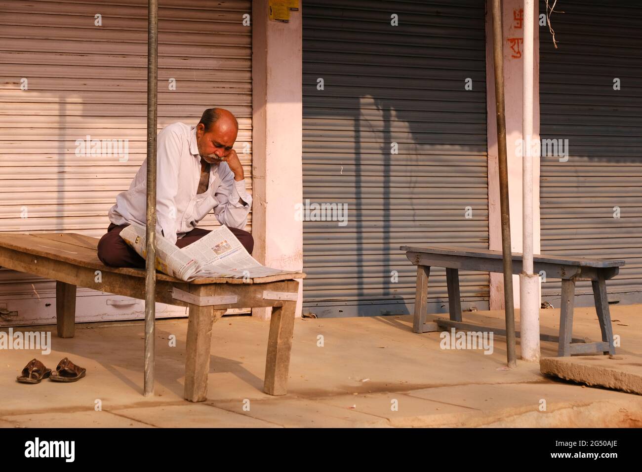 Uttar Pradesh, Indien, 05. Februar 2021, EIN Mann, der Zeitung vor den nahestehenden Geschäften liest. Stockfoto