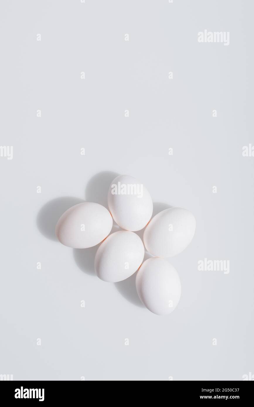 Draufsicht auf ungekochte und organische Eier in Schale auf weißem Hintergrund Stockfoto