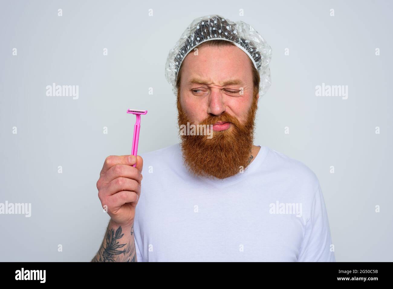 Zweifler Mann will den Bart mit einer Rasierklinge einstellen Stockfoto