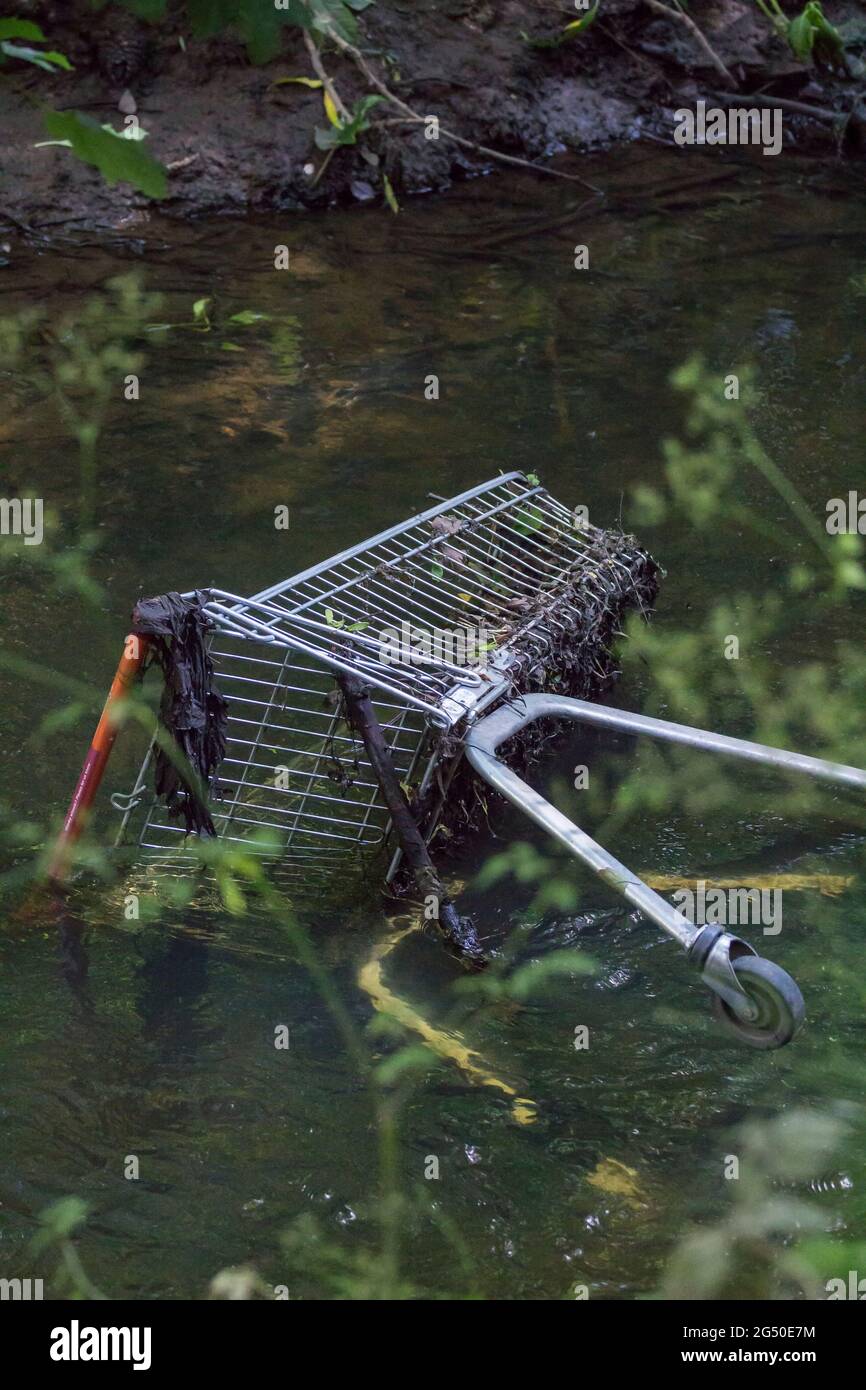 Einkaufskorb im Fluss arun Horsham uk am steilen Ufer abgeladen, enthüllt durch niedrigen Wasserstand, halb untergetaucht Metall Supermarkt Trolly auf Flussbett Stockfoto
