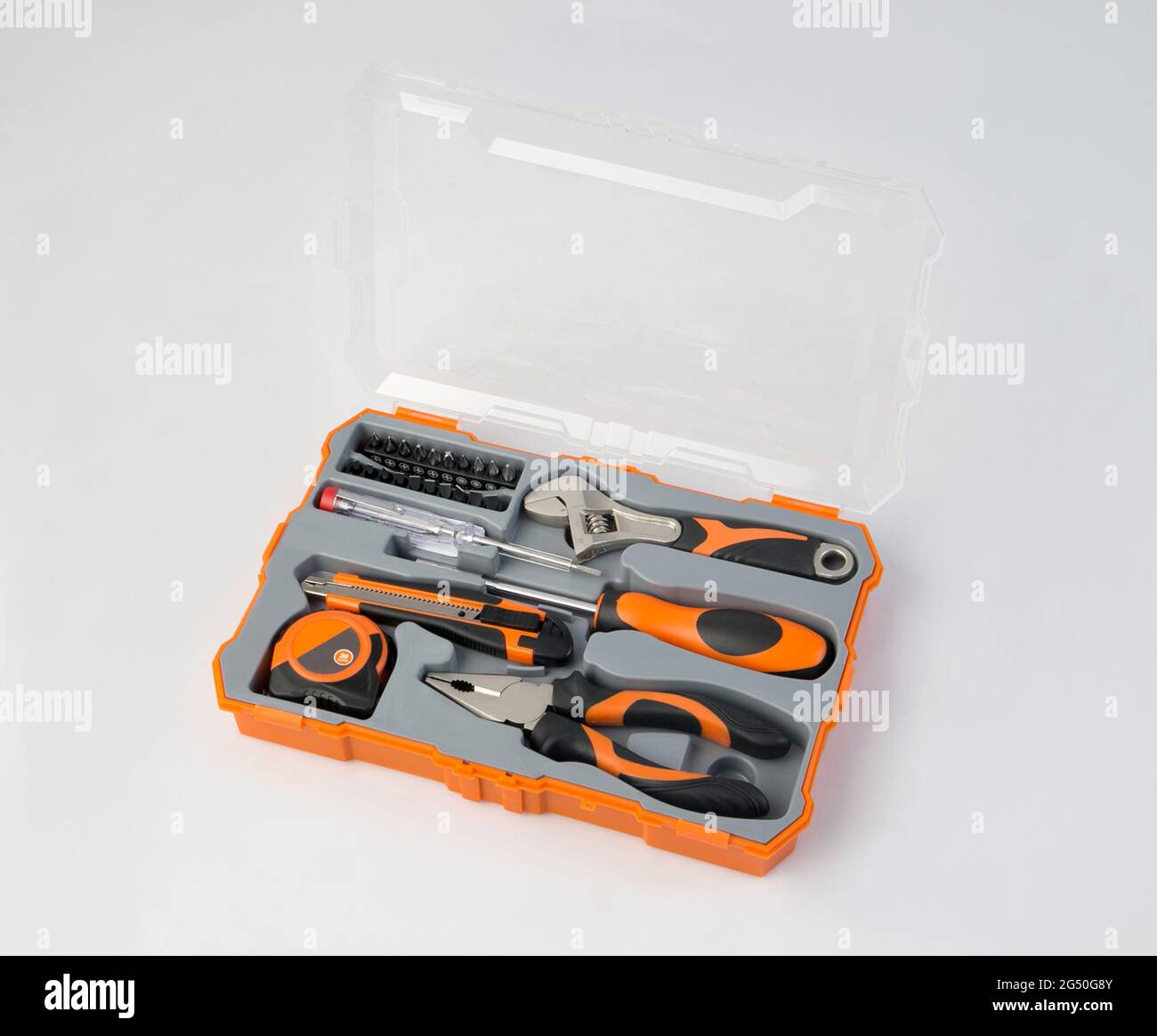 Orangefarbener Werkzeugkasten mit isoliertem Instrument und Werkzeugen auf weißem Hintergrund Stockfoto