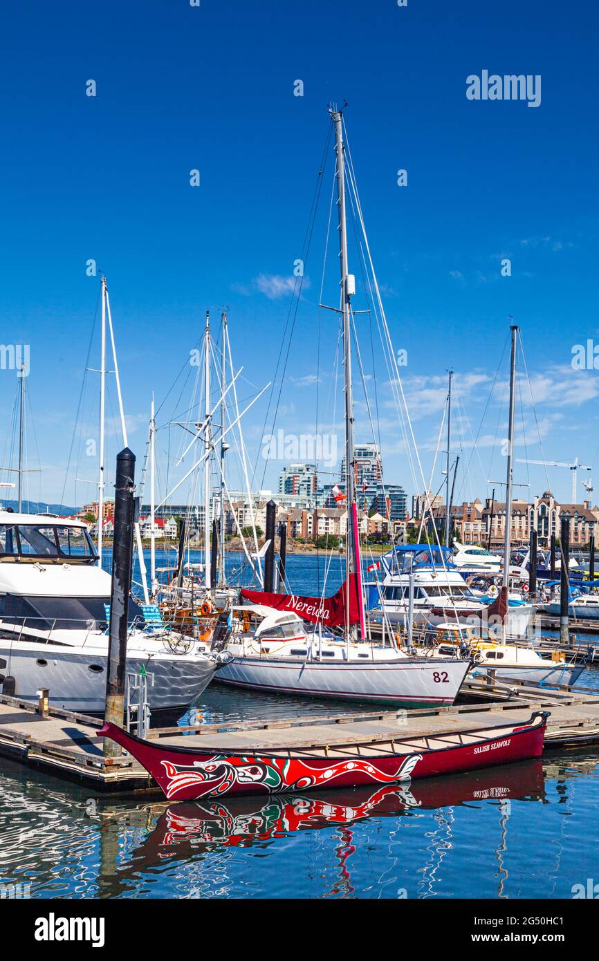 Modernes First Nations-Kanu, das an einem Dock im Binnenhafen Victoria British Columbia Canada mit traditioneller einheimischer Kunst an der Westküste dekoriert ist Stockfoto