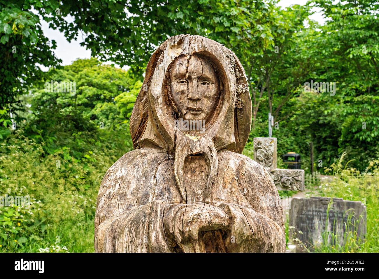 Kettensägen-Schnitzwerk von Fisherman's Wife (gegenüber ihrem Mann stehend) von Tim Burgess auf dem Holy Trinity Churchyard, Morecambe, Lancashire Stockfoto