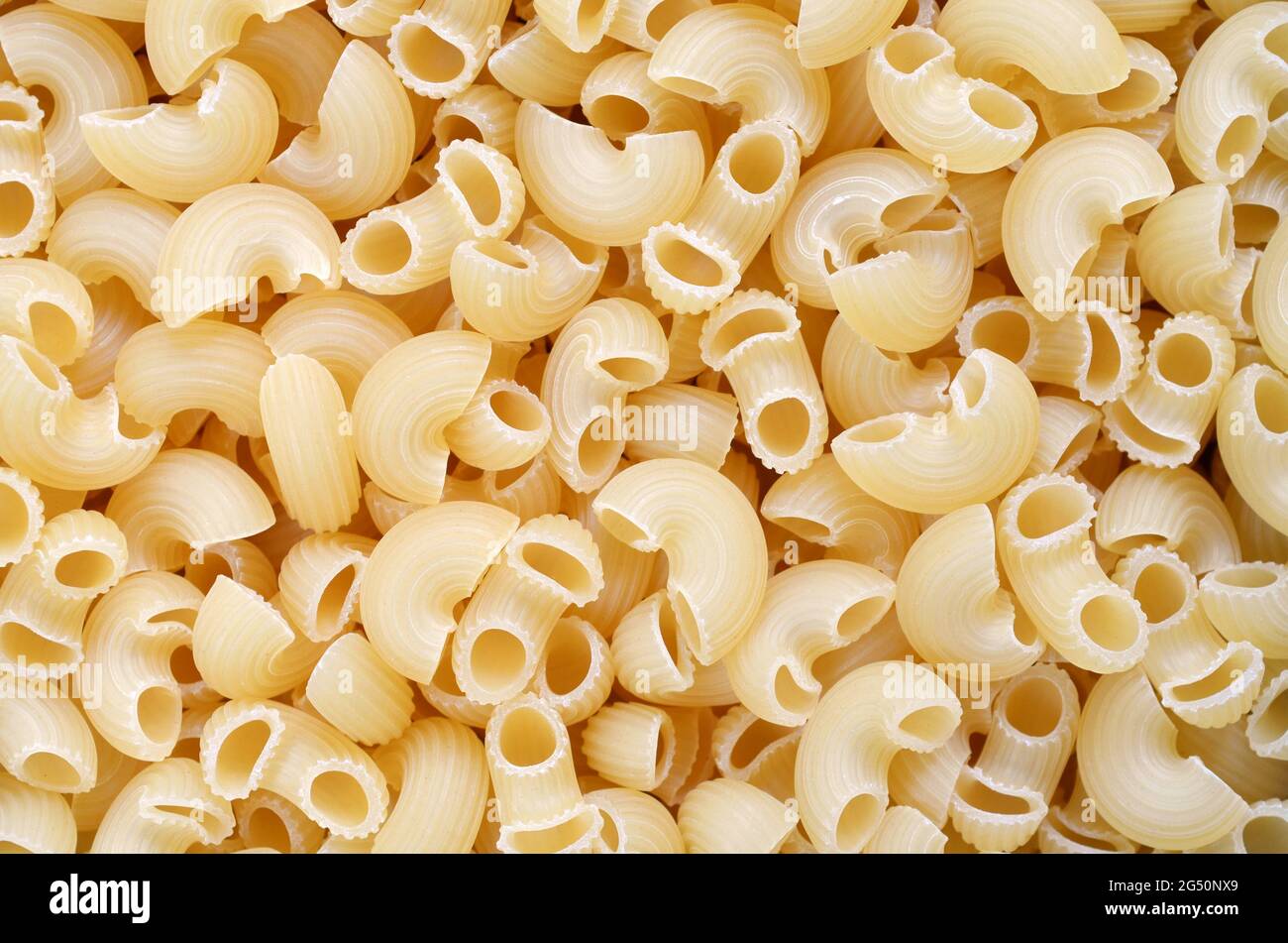 Ungekochte Pfeife-Rigate-Makkaroni, die als Hintergrundtextur verwendet werden, Draufsicht. Stockfoto