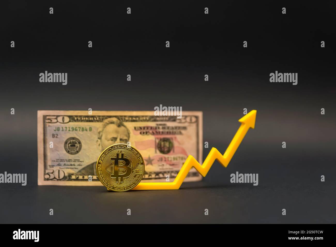 Bitcoin-Preis, Kryptowährungswert. Pfeil nach oben, Diagramm, Symbol. Bitcoin-Münze auf dem Hintergrund einer 50-Dollar-Banknote, auf schwarzem Hintergrund. Stockfoto