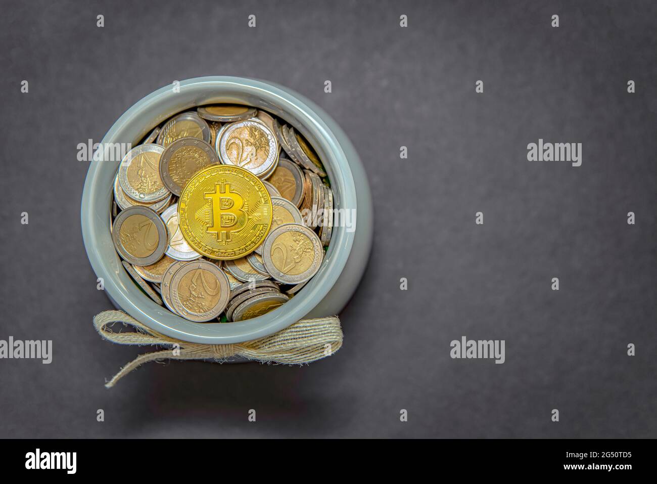 Die Bitcoin-Münze liegt im Sparschwein auf fiat-Münzen. Akkumulation von Kryptowährungen und Investitionssymbol Stockfoto