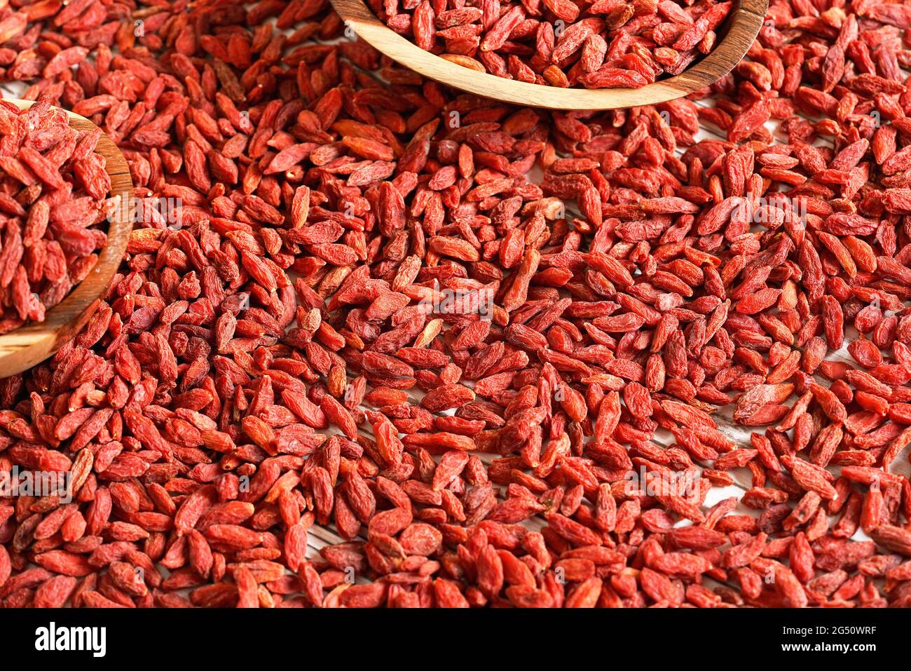 Trockene Goji-Beeren in kleinen Holzschüsseln, verteilt auf dem Schreibtisch unten Stockfoto
