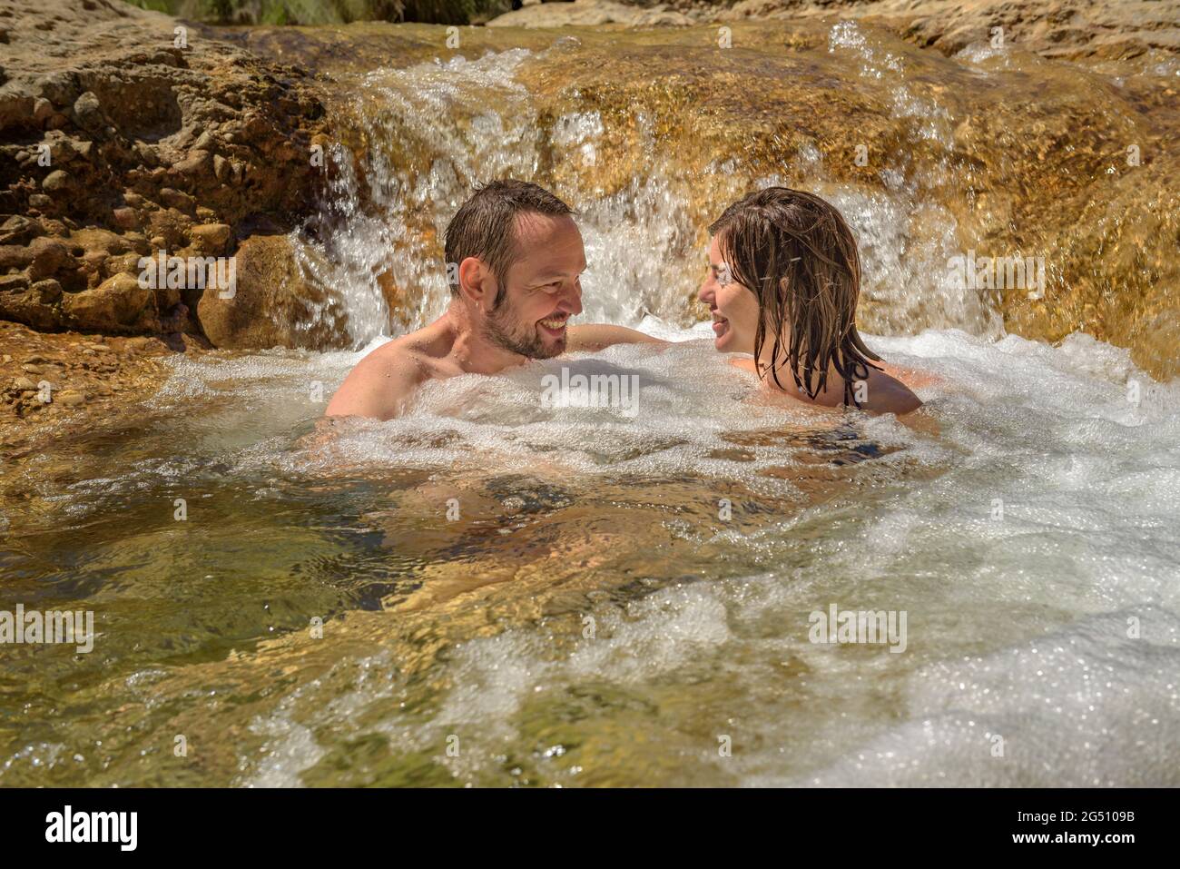 Pärchen, die ein Bad im Naturpool Olles am Fluss Canaletes genießen, Horta de Sant Joan (Terra Alta, Tarragona, Katalonien, Spanien) Stockfoto